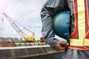 construction worker checking location site with crane on the background